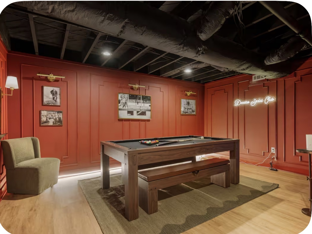 Moody billiard room with red felt pool table, dark walls and pendant lighting