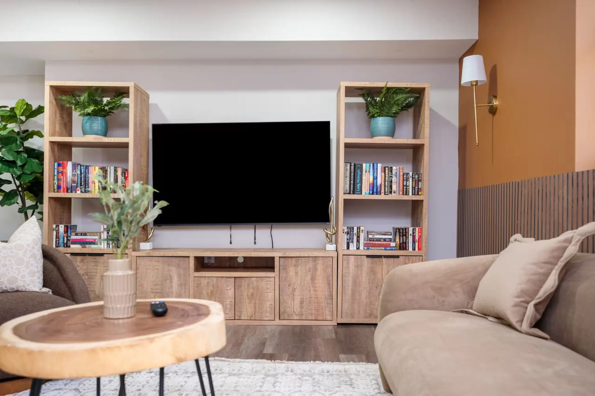 Media lounge with wood shelving, styled bookshelves, and live-edge coffee table