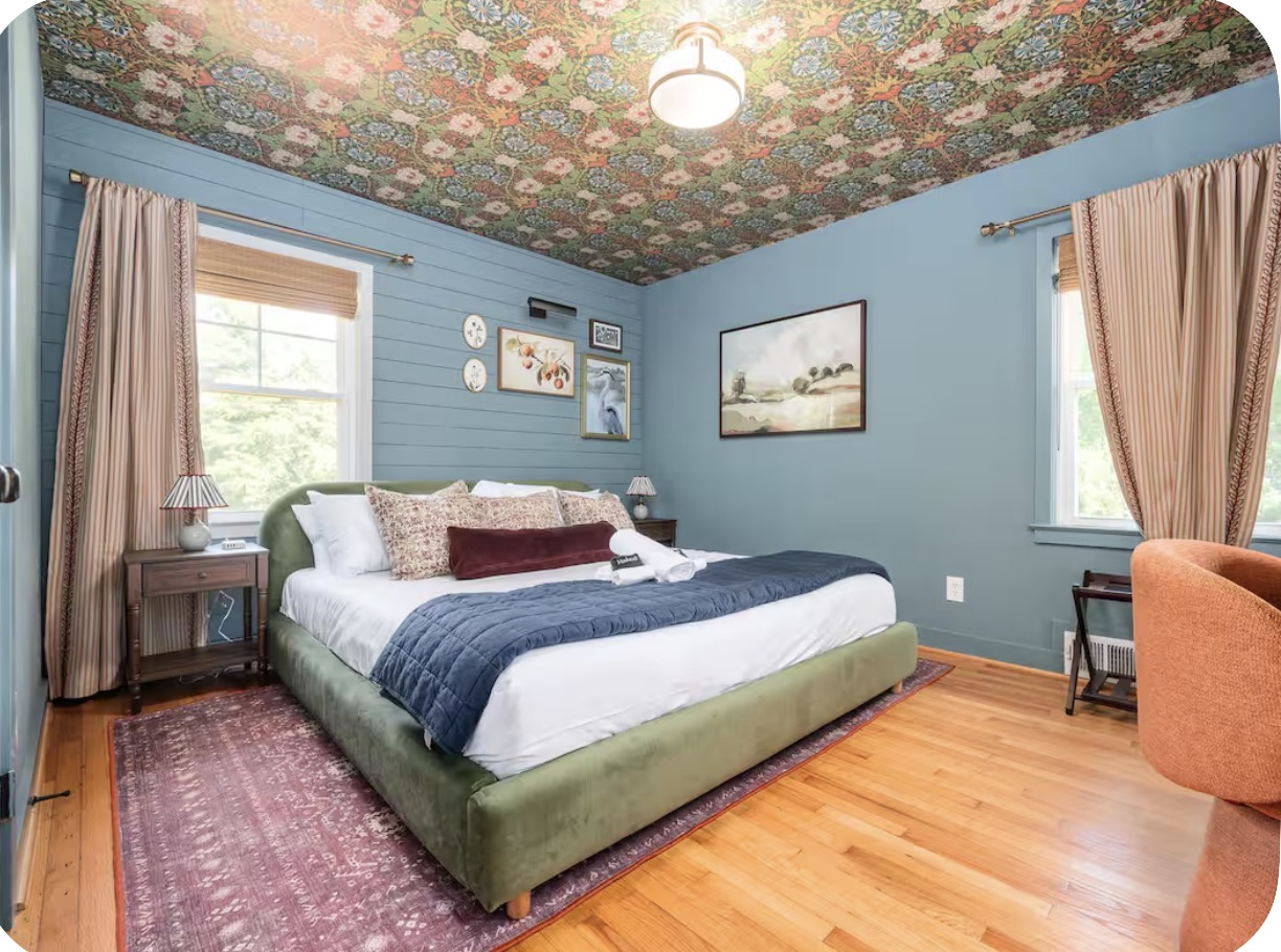 Guest bedroom with floral papered ceiling, blue shiplap walls and olive velvet bed