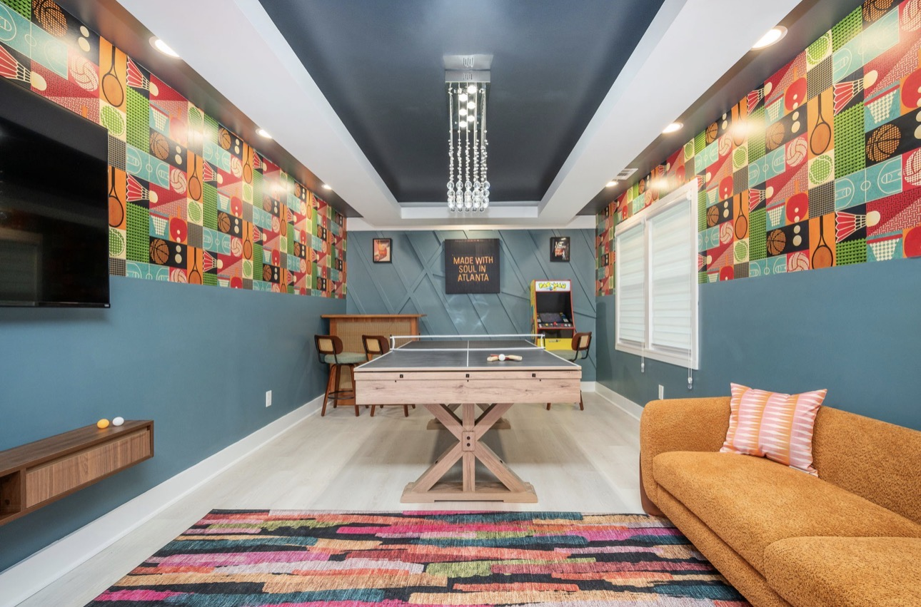 Atlanta-inspired game room with ping-pong table, arcade cabinet and sport-print wallpaper