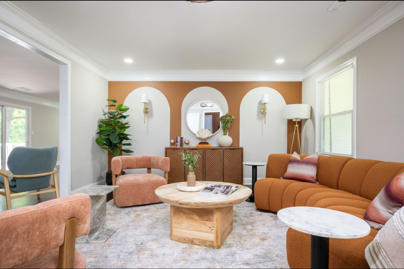 Full living room view with the custom terracotta arch feature wall and curved sofa