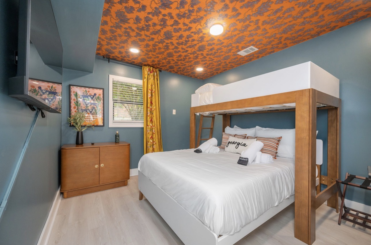 Georgia bunk bedroom with orange botanical ceiling wallpaper and king bunk bed