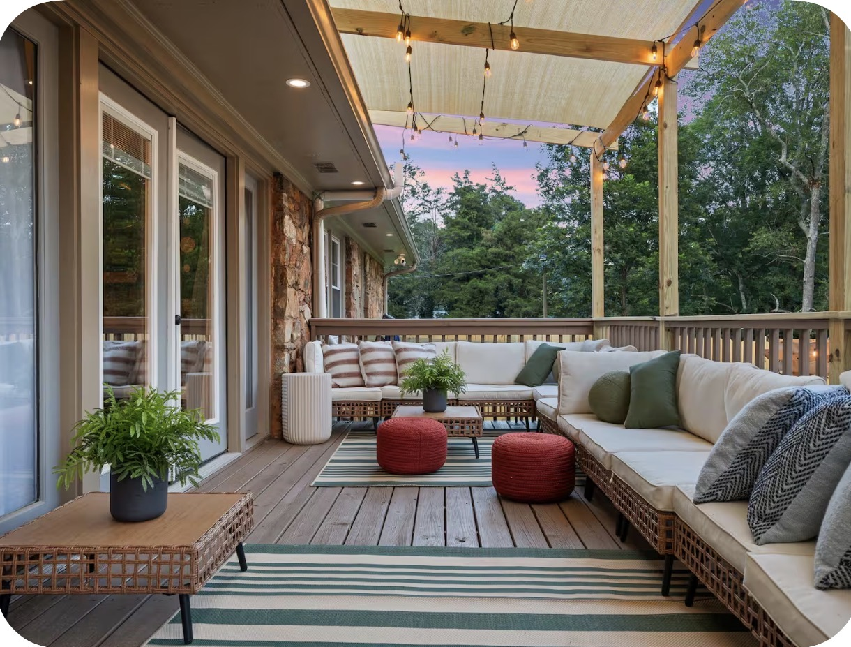Covered pergola porch lounge with deep seating and string lights at dusk