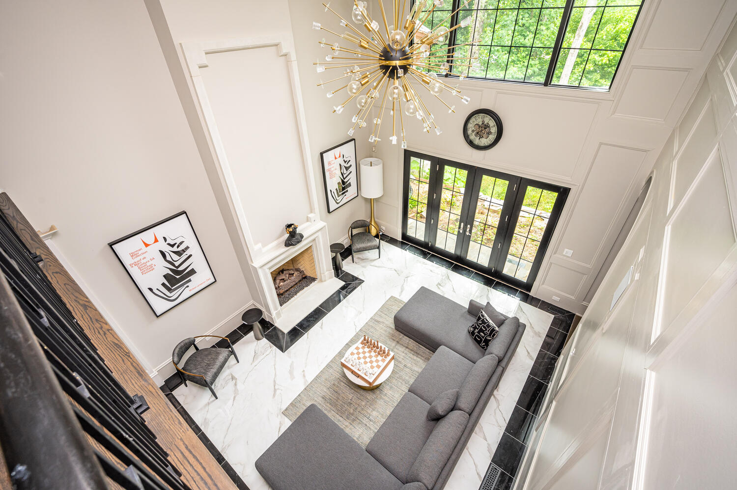 Two-story living room with marble floors, sputnik chandelier, and modern sectional