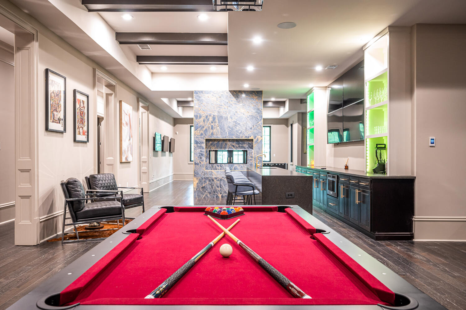 Lower-level game room with red felt pool table, wet bar, and lounge seating