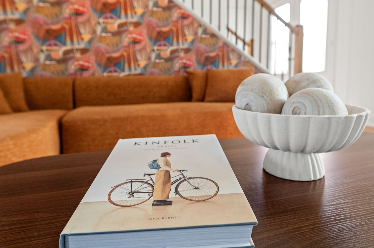 Styled coffee table detail with stacked design books, tray and greenery